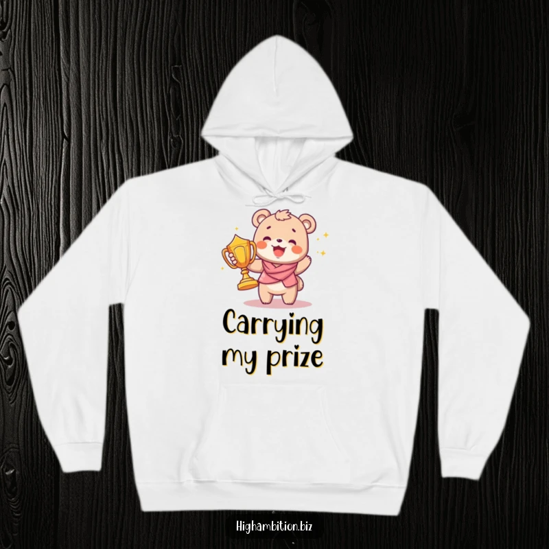 Funny hoodie showing a joyful bear cub character carrying a big, shiny trophy, radiating pride and accomplishment.
